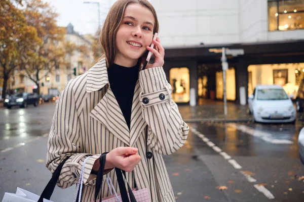 Hübsches Lächelndes Mädchen Das Fröhlich Auf Dem Smartphone Mit Einkaufstaschen — Stockfoto