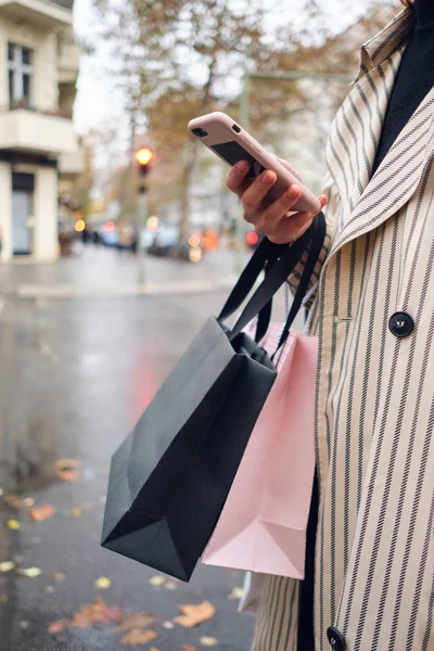 Close Lässig Mädchen Mit Einkaufstaschen Mit Smartphone Auf Verregneter Straße — Stockfoto