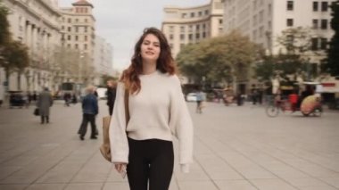 Sırt çantalı güzel bir kızın güzel şehir caddesinde mutlu mesut yürürken çekilen görüntülerini izliyorum.