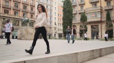 Güzel şehir caddesinde, sırt çantalı, kendine güvenen güzel bir kızın görüntüsü.