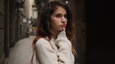 Dar şehir caddesinde duran güzel düşünceli kız. Düşünen yüz ifadesiyle düşünceli İspanyol turist kız.