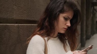 Barcelona 'nın dar sokağında akıllı telefon kullanan ciddi İspanyol kızın görüntüsü.