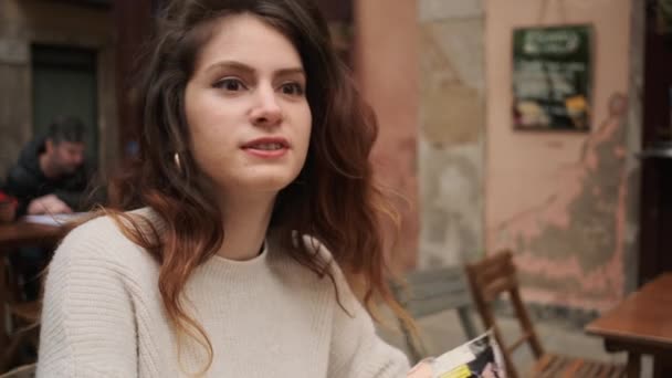 Досить Стильна Іспаномовна Дівчина Щасливо Розмовляє Другом Сидячи Навпроти Під — стокове відео