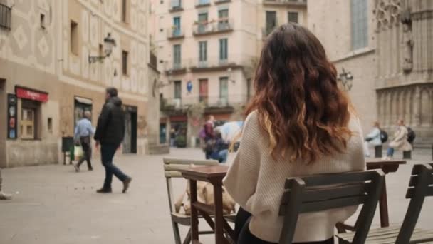 在城市广场的一家舒适的咖啡馆里 一个美丽的女孩与一杯红葡萄酒共眠 她的照片围绕着她的概念进行跟踪 — 图库视频影像
