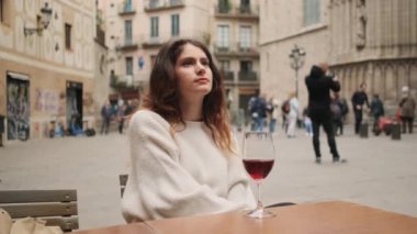 Şehir meydanındaki açık kafede bir kadeh şarapla uyuyan rüya gibi İspanyol bir kız.
