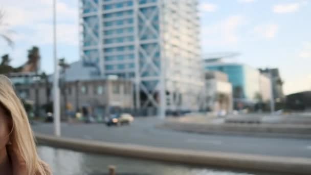 도시를 동안아름다운 금발의 소녀가 카메라를 포즈를 취하는 장면을 추적하는 — 비디오