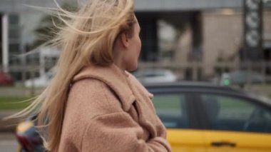 Havalı ceketli güzel, romantik sarışın kız rüyasında şehir caddesinde taksi parkında yürüyordu. 