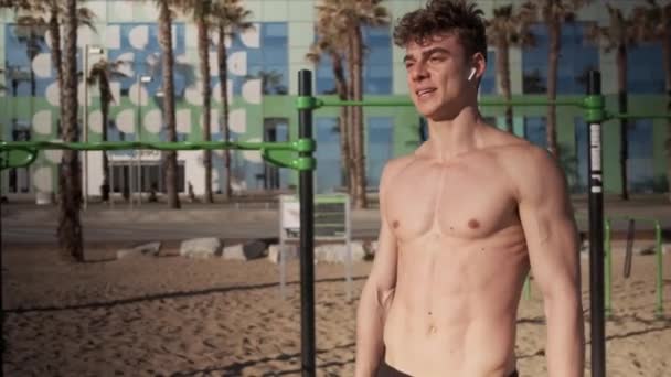 Joven Hombre Musculoso Deportivo Con Auriculares Inalámbricos Playa Barcelona — Vídeos de Stock