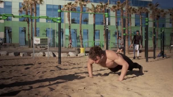 バルセロナの海辺の陸上競技場で機能訓練中に練習を行う魅力的なフィット男 — ストック動画