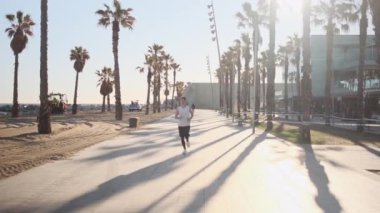 Barcelona 'nın güzel sahil şeridi boyunca koşan genç ve çekici bir sporcunun görüntüsü.