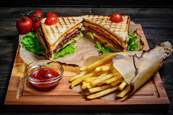 Sandwich de atún con salsa y papas fritas en una mesa de madera — Foto de Stock