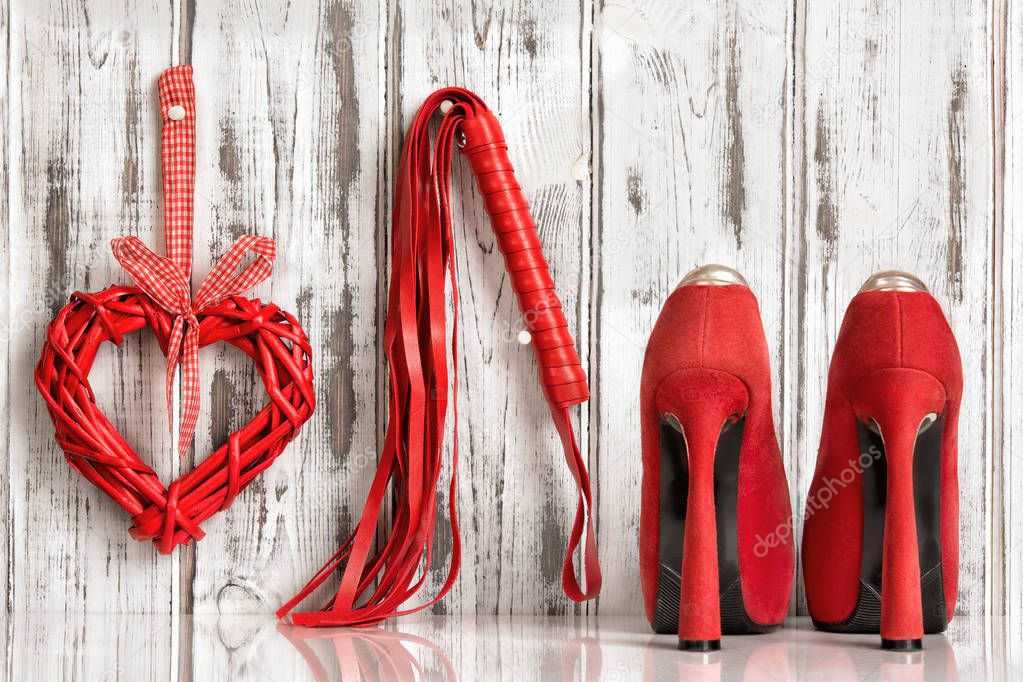 red shoes lash heart handcuffs on a wooden background