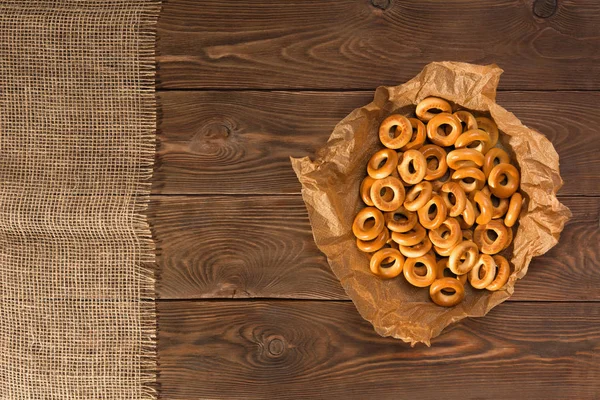 Bagel kering kecil di meja kayu, tampilan atas . — Stok Foto