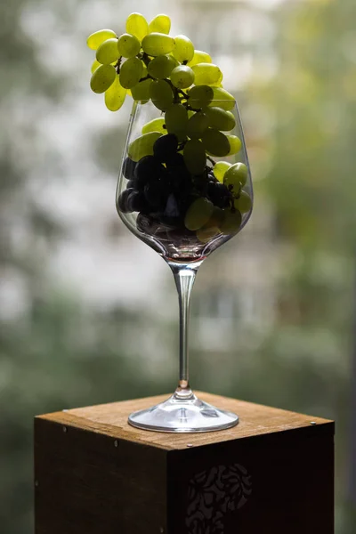 Bir gıda fotoğraf uyumsuz görüntüleri birleştirir. Kırmızı ve Yeşil üzüm şarap bir bardak fırçalar aristokrat ve kışkırtıcı görünüyorsun. Gastronomik bir ecstasy Üstten Görünüm