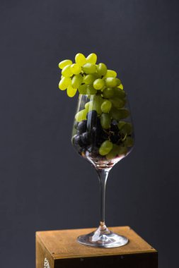 Bir gıda fotoğraf uyumsuz görüntüleri birleştirir. Kırmızı ve Yeşil üzüm şarap bir bardak fırçalar aristokrat ve kışkırtıcı görünüyorsun. Gastronomik bir ecstasy Üstten Görünüm