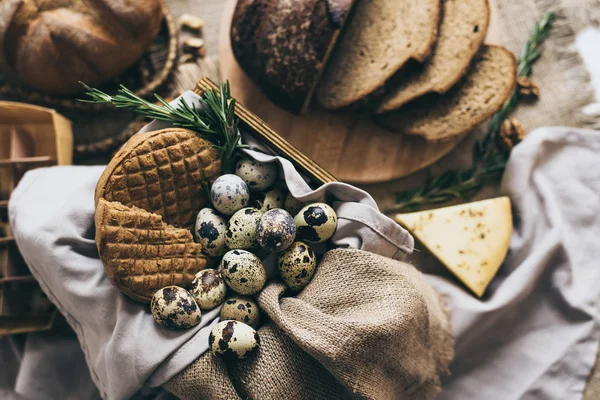 Bıldırcın yumurtası, otlar, peynir ekmek pasta dilimleri düz yatıyordu. Sarı bardak süt. Yas ve zanaat bej bir dekorasyon olarak kullanılan peçete. Sağlıklı kahvaltı için sevgili bir.