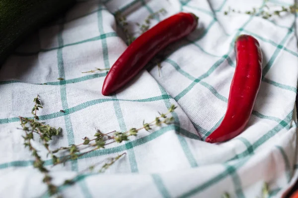 İki kırmızı sıcak biber bol dökümlü bir kumaş üzerine yalan söylüyorsun. Hurbs dekorasyon olarak kullanılır.