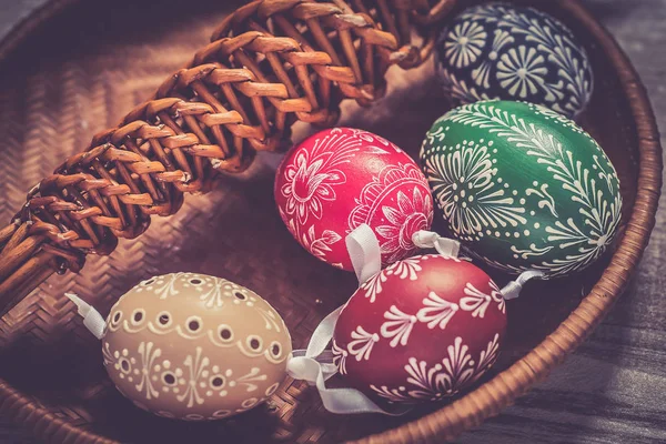 Домашние и ручные пасхальные яйца на березовых ветвях на деревянном подносе, традиционный чешский, охота за пасхальными яйцами, кнут с лентами — стоковое фото