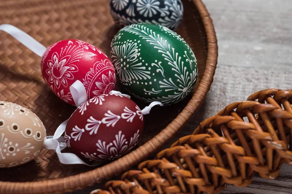 Huevos de Pascua caseros y hechos a mano en ramas de abedul en bandeja de madera, checa tradicional, caza de huevos de Pascua, látigo con cintas — Foto de Stock