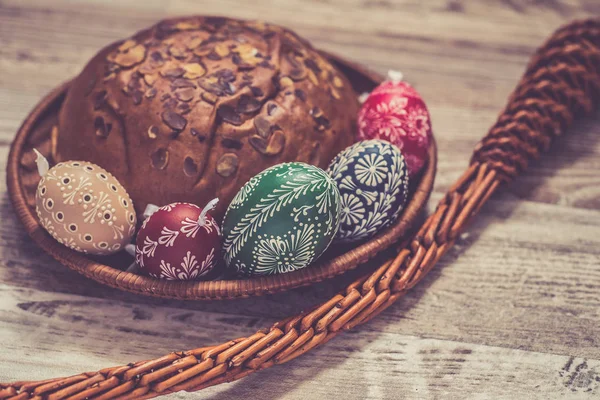Домашние и ручные пасхальные яйца на березовых ветвях на деревянном подносе, традиционный чешский, охота за пасхальными яйцами, кнут с лентами — стоковое фото