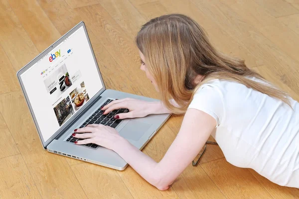 Mädchen auf ebay-Laptop Stockbild