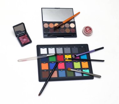 Beyaz arkaplanda makyaj fırçası olan renkli göz falı paletleri