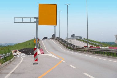 Kenarlarında manzara ve trafik levhası olan boş bir otoyol.