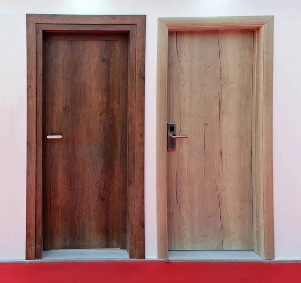 地板上铺着红地毯的两扇木制材料房入口门 — 图库照片