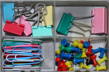 Modern metal ofis kağıt ataçları ve klasörleri plastik kutunun içine istiflenir