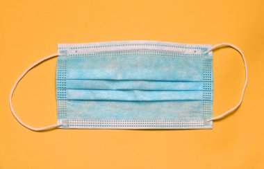 Sarı arka planda cerrahi tıbbi yüz maskesi