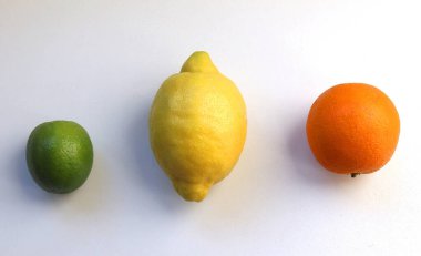 Beyaz zemin üzerinde organik narenciye meyveleri trafik ışıkları renklerinde düzenlenmiştir