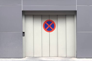 Kapalı garaj kapısı. Dışarısı yasak trafik levhası.