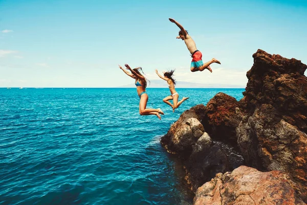 Vänner klippa hoppa i havet — Stockfoto