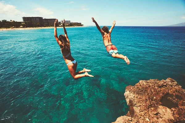 Amigos penhasco pulando no oceano — Fotografia de Stock
