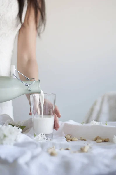 Chica verter anacardo leche — Foto de Stock