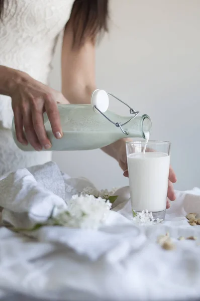 Chica verter anacardo leche — Foto de Stock