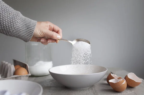 Женщина добавляет сахар в миску — стоковое фото