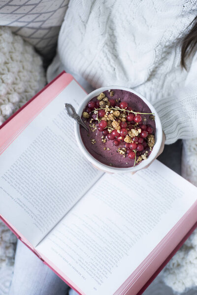 woman holding book and Acai Bowl 
