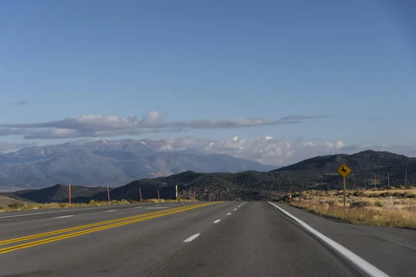 Strada vuota con montagne maestose — Foto Stock