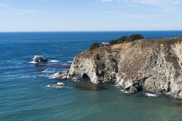 rocky cliffs and calm Pacific Ocean