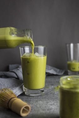 Yeşil matcha çay şişe Cam masaya dökülen