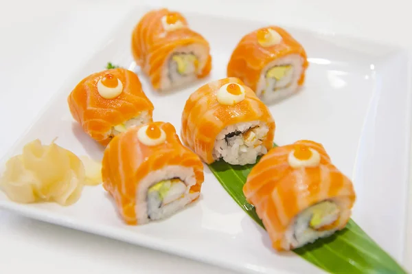 Rollo de sushi de salmón con queso crema en plato blanco, estilo japonés — Foto de Stock