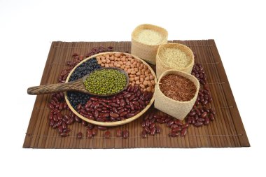 Hububat ve tohum fasulye (siyah fasulye, kırmızı fasulye, fıstık, Mung fasulye, Tayland Yasemin pirinç, kahverengi pirinç ve beyaz pirinç) beyaz zemin üzerine tahta kaşık sağlık için yararlı.