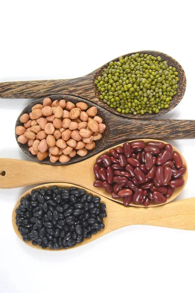 Tohum fasulye (siyah fasulye, kırmızı fasulye, fıstık ve Mung fasulye) beyaz zemin üzerine tahta kaşık sağlık için yararlı. — Stok fotoğraf