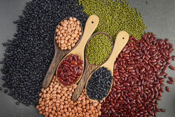 Seeds beans(Black Bean, Red Bean, Peanut and Mung Bean) useful for health in wood spoons on grey background.