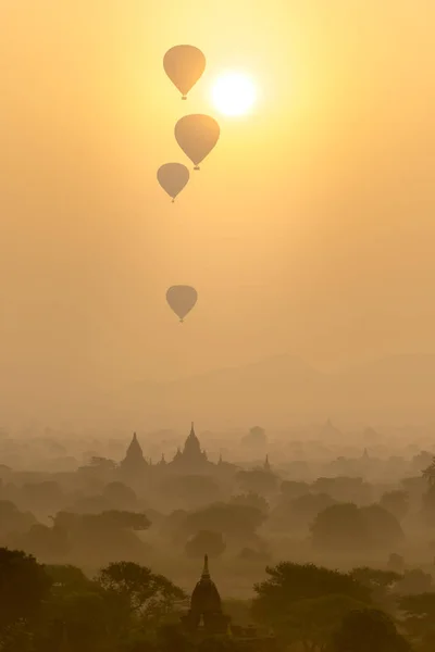 Horkovzdušné balóny létat nad bojištěm starobylé město pagody na siluetu sunrise scéně v Bagan, Myanmar. — Stock fotografie
