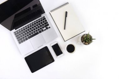 Dizüstü bilgisayar, dizüstü bilgisayar, dijital tablet ve beyaz arka plan üzerinde smartphone ile ofis masaları.