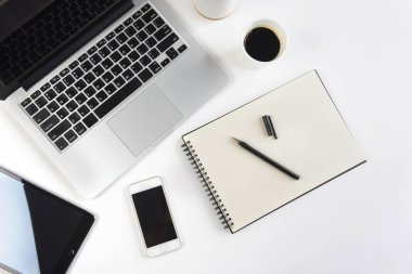 Dizüstü bilgisayar, dizüstü bilgisayar, dijital tablet ve beyaz arka plan üzerinde smartphone ile ofis masaları.