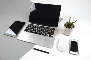 Dizüstü bilgisayar, dizüstü bilgisayar, dijital tablet ve modern iki ton (beyaz ve gri) arka plan üstünde smartphone ile ofis masaları.