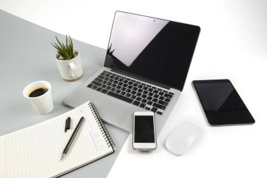 Dizüstü bilgisayar, dizüstü bilgisayar, dijital tablet ve modern iki ton (beyaz ve gri) arka plan üstünde smartphone ile ofis masaları.